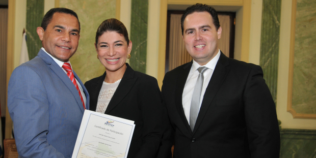 Rafael Ovalles y Francis Coste entregan certificado a egresada