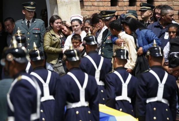 Los familiares de los 11 soldados asesinados en una emboscada por la guerrilla del Ejército de Liberación Nacional, ELN, lloran cuando los féretros son llevados al interior de la iglesia en el funeral realizado en Bogotá, Colombia, el jueves 29 de octubre de 2015. (AP Photo/Fernando Vergara)