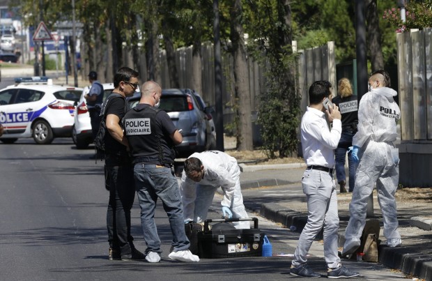 Agentes de la policía francesa trabajan cerca de un autobús en el distrito de La Valentine, después de que una camioneta embistiera contra dos paradas de autobús en la ciudad francesa de Marsella, en el sur de Francia, el lunes 21 de agosto de 2017. (AP Foto/Claude Paris)